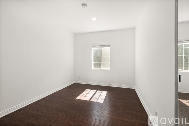 A room with a window and wooden flooring.