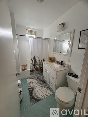 A bathroom with a toilet, sink, and shower.