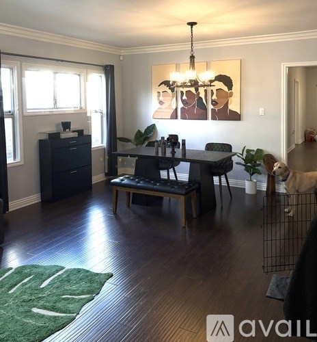 A room with a dining table and chairs, a dresser, and a painting on the wall.