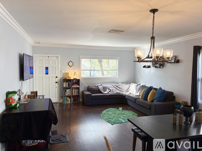 A living room with a couch, a coffee table, and a chandelier.