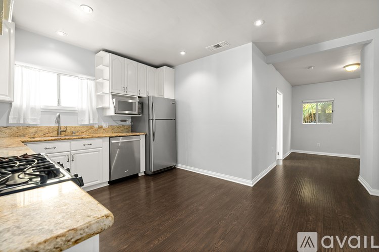 A kitchen with a granite countertop and stove top.