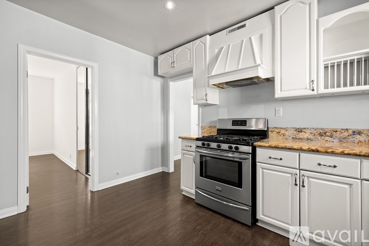 A kitchen with white cabinets and a granite countertop.