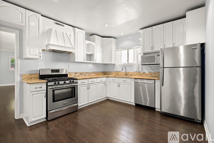 A modern kitchen with white cabinets and stainless steel appliances.