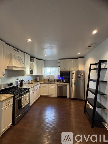 A kitchen with white cabinets and a black stove top oven.