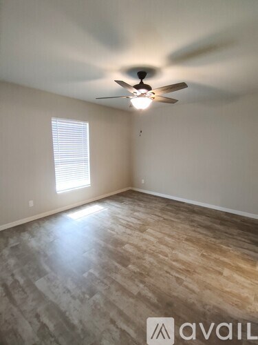 A room with a ceiling fan and wooden flooring.
