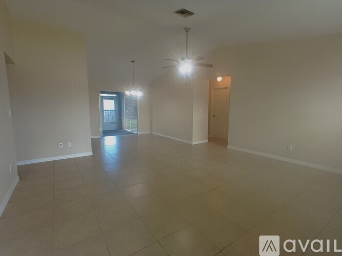 A spacious room with tiled flooring and a ceiling fan.
