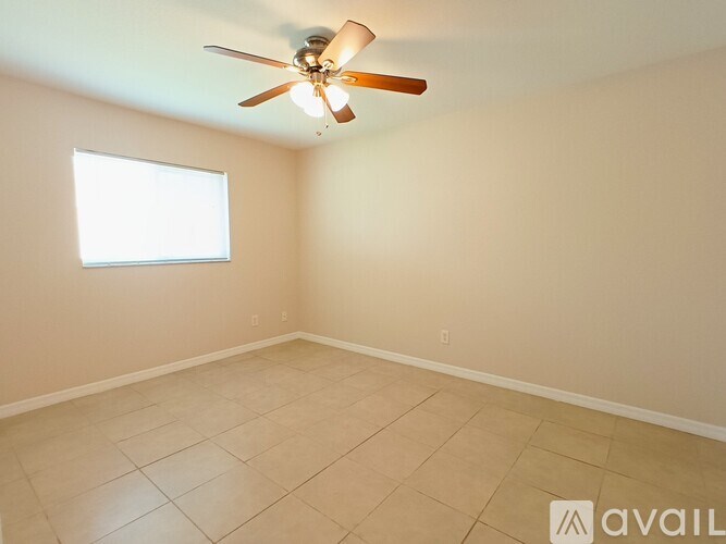 A room with a ceiling fan and a window.