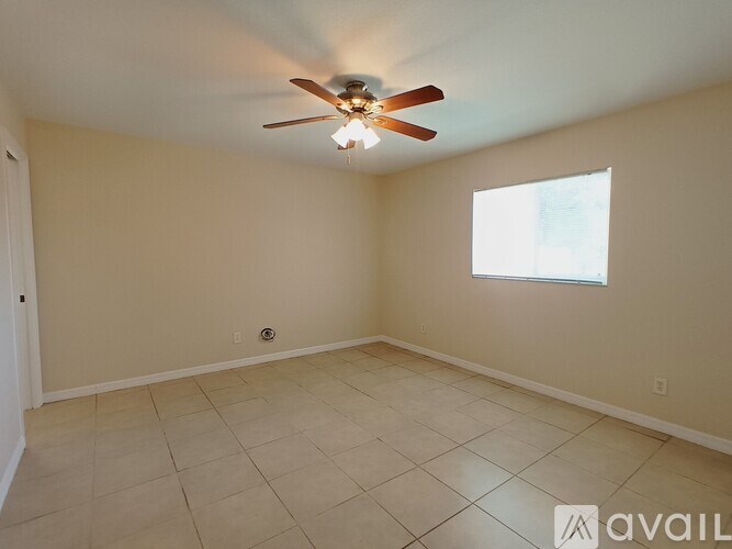 A room with a ceiling fan and a window.