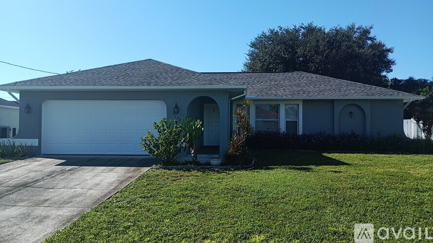 A house with a garage and a driveway in front of it.
