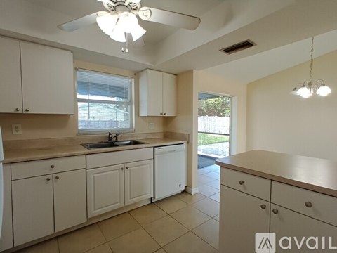 A kitchen with white cabinets and a sink.