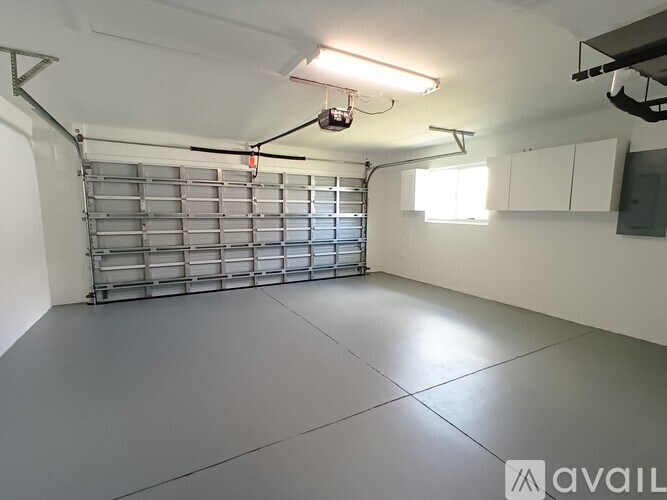 A spacious garage with a grey floor and white walls.