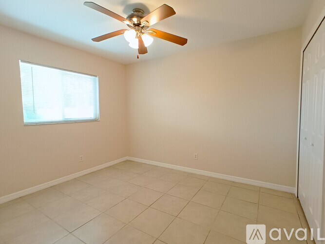 A room with a ceiling fan and a window.