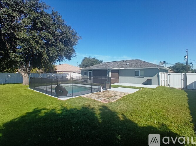 A backyard with a pool and a house.