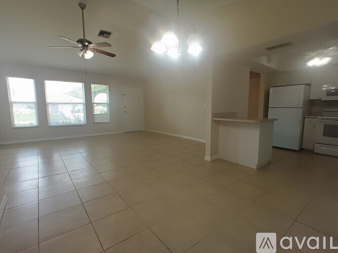 A spacious room with a fan and tiled flooring.