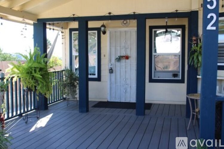 A porch with a white door and a window.