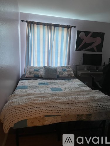 A bed with a white blanket and pillows in a room.