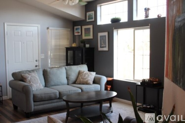 A living room with a grey couch and a black cabinet.