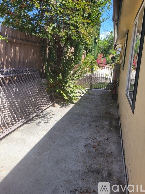 A concrete pathway leads to a metal gate.