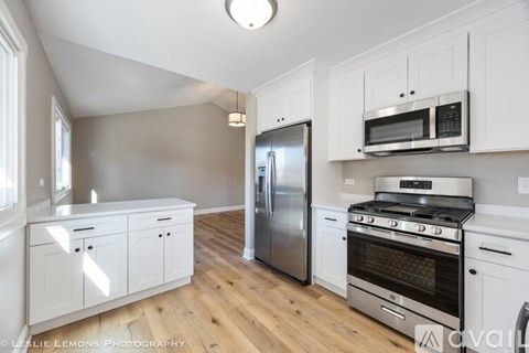 A kitchen with white cabinets and stainless steel appliances.
