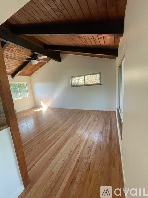 A room with wooden floors and a ceiling fan.