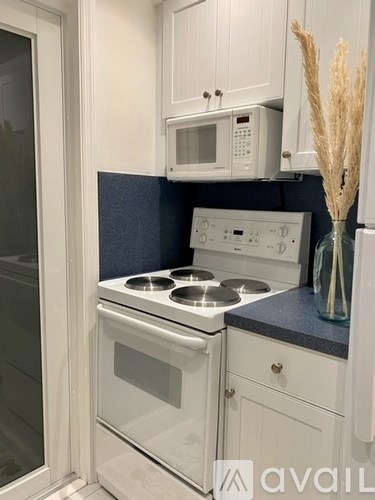 A kitchen with a white oven and microwave.