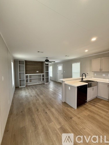 A modern kitchen with wooden floors and white walls.