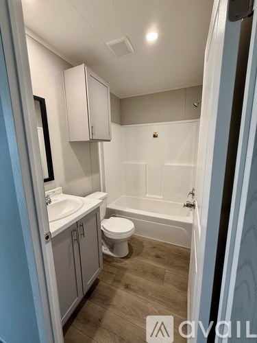 A small, clean bathroom with a toilet, sink, and bathtub.