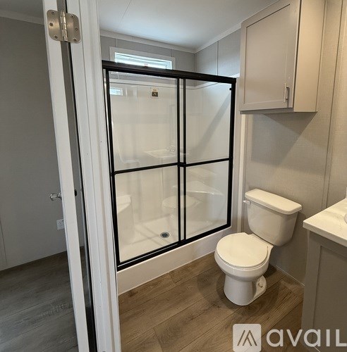 A white toilet in a bathroom with a glass door.