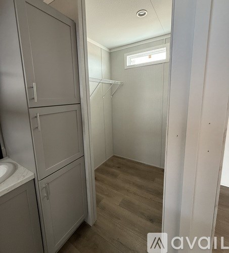 A small, empty bathroom with a sink and a window.