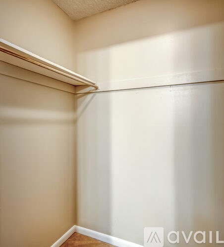 A white wall with a wooden floor and a white door.