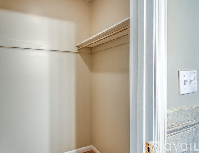 A white door with a handle and a small square object on the wall.