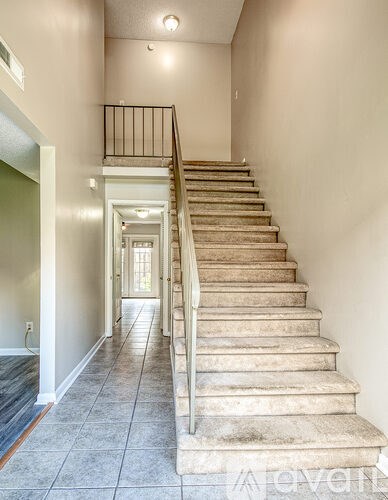 A staircase with a metal railing leads to a doorway.