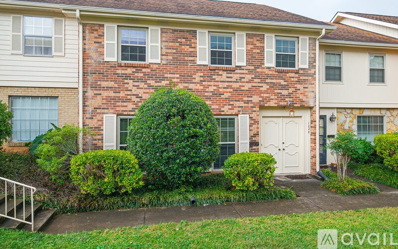 A brick house with a white door and windows.