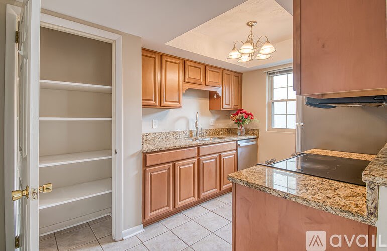 A kitchen with brown cabinets and a granite countertop.