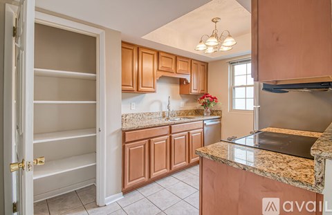 A kitchen with brown cabinets and a granite countertop.