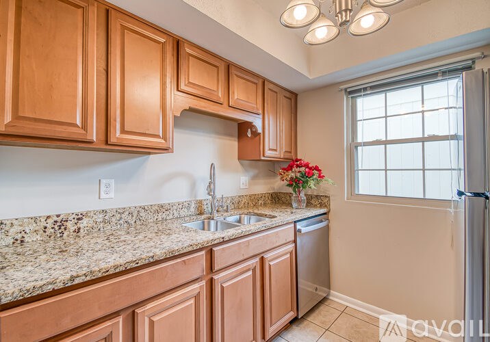A kitchen with wooden cabinets and granite countertops.