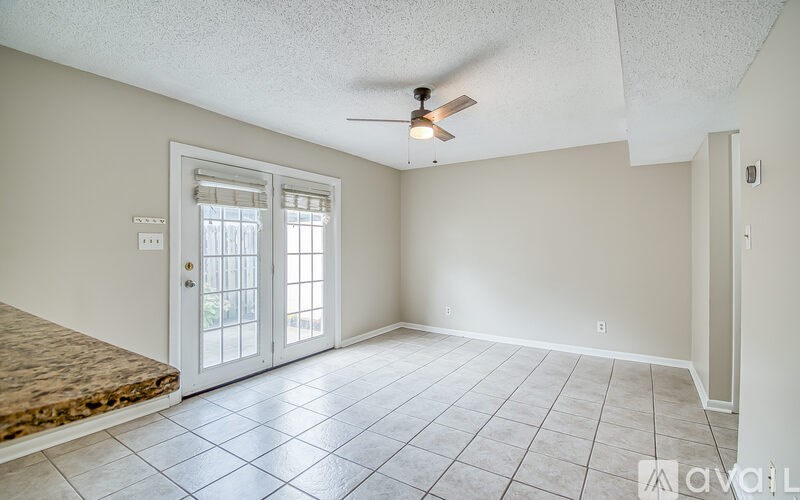 A room with a ceiling fan and a door leading outside.