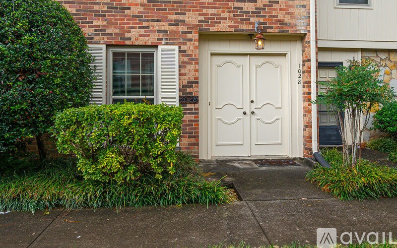 A white door is on the front of a brick house.