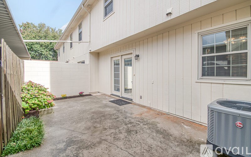 A house with a white exterior and a grey air conditioner unit in the yard.