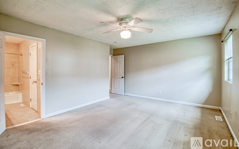 A room with a ceiling fan and two doors.