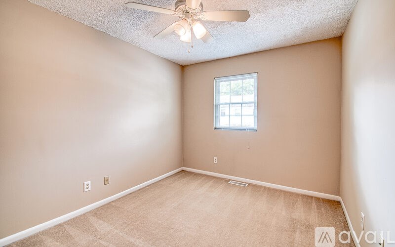 A room with a ceiling fan and a window.