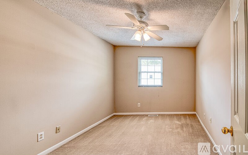 A room with a ceiling fan and a window.