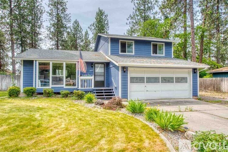 A blue house with a flag on the porch.