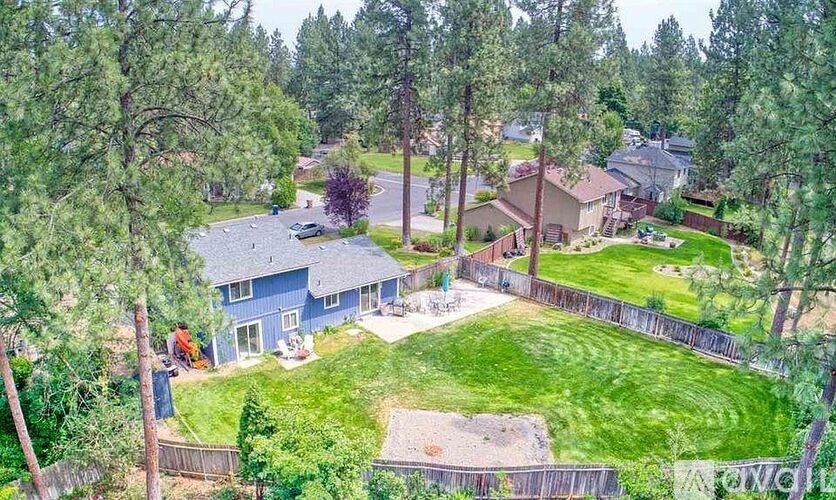 A house surrounded by a fence and trees.
