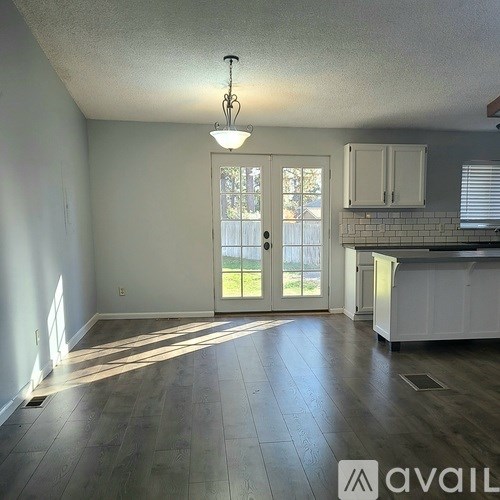 A sunny kitchen with a white door leading to a backyard.