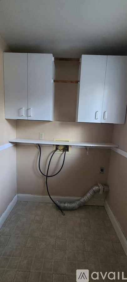 A room with a tiled floor and a wall-mounted cabinet.