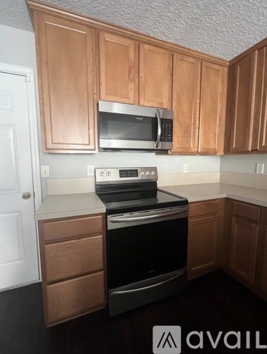 A kitchen with wooden cabinets and a black stove top oven.