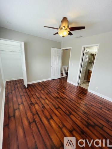 A room with wooden floors and a ceiling fan.