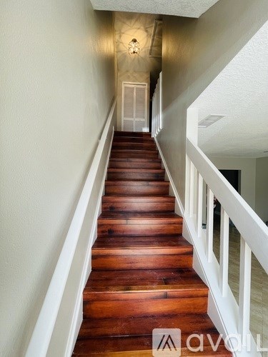 A wooden staircase with white railings.