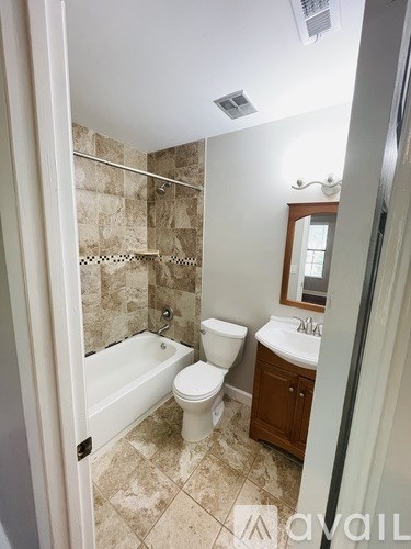 A bathroom with a toilet, sink, and bathtub.